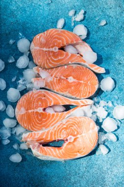 Somon balığı. Çiğ alabalık, kırmızı balık bifteği, yeşillik, limon ve zeytinyağı ile servis edilir. Somon pişirmek, deniz ürünleri. Sağlıklı yeme kavramı.