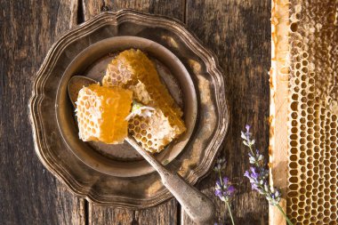 Balmumu ve sıvı doğal sarı bal içeren bal peteği parçası. Kırsal kesim. Arı ürünleri organik doğal bileşenler kavramına göre