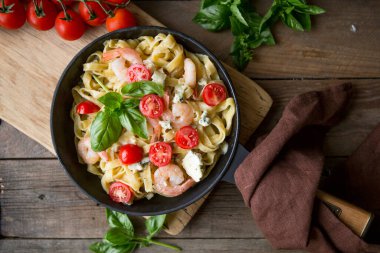 Karidesli, karidesli, domatesli ve fesleğenli Penne Makarnası ahşap, üst manzara, kopyalama alanı.