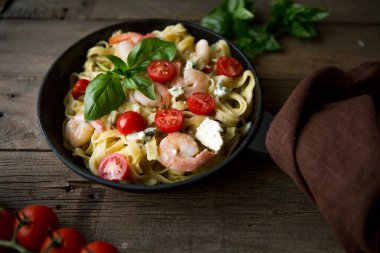 Karidesli, karidesli, domatesli ve fesleğenli Penne Makarnası ahşap, üst manzara, kopyalama alanı.