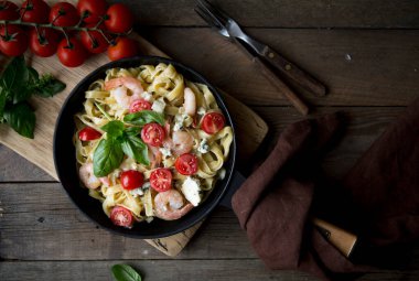 Karidesli, karidesli, domatesli ve fesleğenli Penne Makarnası ahşap, üst manzara, kopyalama alanı.