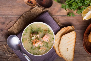 İskandinav ya da Norveç balık çorbası kasede, tahta kesme tahtası, kaşık