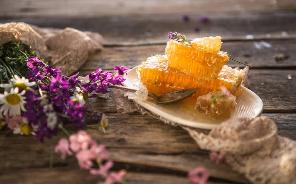 Balmumu ve sıvı doğal sarı bal içeren bal peteği parçası. Kırsal kesim. Arı ürünleri organik doğal bileşenler kavramına göre