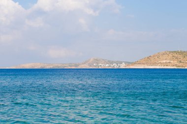 Temiz mavi suyu, altın kumu, renkli tekneleri ve arka planda dağları olan güzel bir sahil manzarası. Yunanistan ve İyon Denizi 'nin yaz manzarası.
