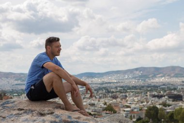 Yunanistan 'ın Atina kentindeki Ulusal Gözlemevine bakan Areopagus manzarasının keyfini çıkaran adam