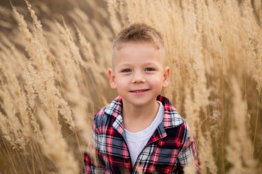 Dışarıda eğlenen küçük şirin bir çocuğun portresi.