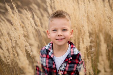 Dışarıda eğlenen küçük şirin bir çocuğun portresi.