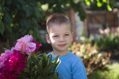 Dışarıda eğlenen küçük şirin bir çocuğun portresi.