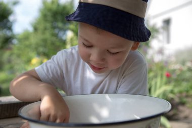 Dışarıda eğlenen küçük şirin bir çocuğun portresi.