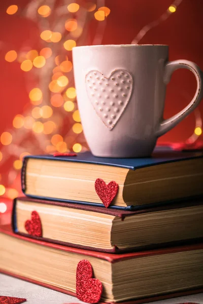 Stack of books and red heart. Romantic background with the book