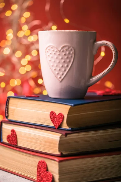 Bir yığın kitap ve kırmızı kalp. Romantik bir geçmişi var.