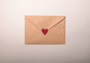 Gri arka planda sevgililer günü kalpleri olan kağıt bir zarf. Düz yerde, üst tarafta. Sevgililer Günü konsepti için romantik aşk mektubu.