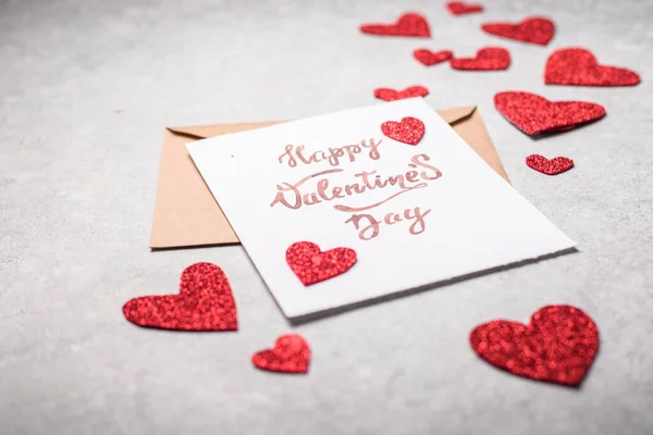 Valentines Day postcard. Happy Valentine \'s day inscription and red  hearts on a vintage concrete gray background