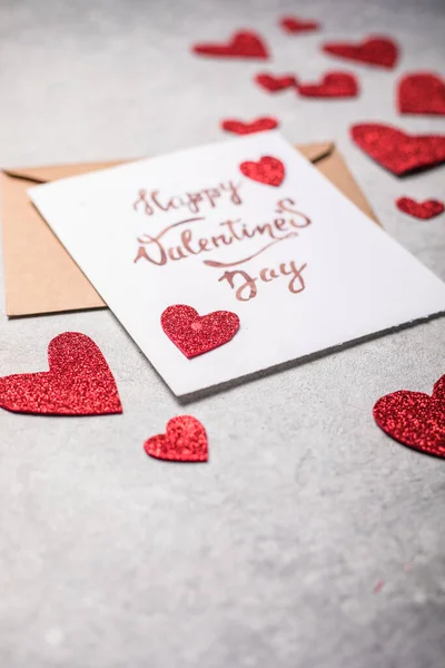 Valentines Day postcard. Happy Valentine \'s day inscription and red  hearts on a vintage concrete gray background