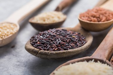 Organik beyaz yasemin pilavı, cilalanmamış siyah ve kahverengi pirinç, ahşap kaşıklarda böğürtlen.