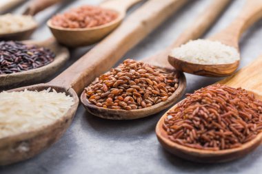 Organik beyaz yasemin pilavı, cilalanmamış siyah ve kahverengi pirinç, ahşap kaşıklarda böğürtlen.