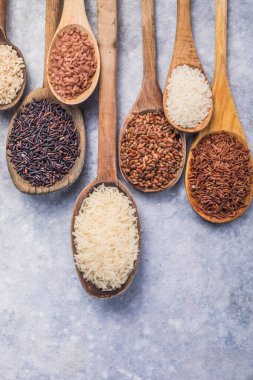 Organik beyaz yasemin pilavı, cilalanmamış siyah ve kahverengi pirinç, ahşap kaşıklarda böğürtlen.