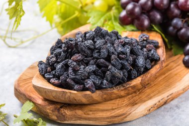 Arka planda siyah kuru üzümler, masa üstü manzaralı. Kurutulmuş meyve, sağlıklı atıştırmalık