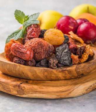 Kurutulmuş meyveler ahşap bir kasede karışıyor. Şekerli meyve çeşitleri. Yahudi bayramı Tu Bishvat. Boşluğu kopyala