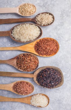 Organik beyaz yasemin pilavı, cilalanmamış siyah ve kahverengi pirinç, ahşap kaşıklarda böğürtlen.