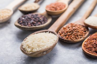 Organik beyaz yasemin pilavı, cilalanmamış siyah ve kahverengi pirinç, ahşap kaşıklarda böğürtlen.