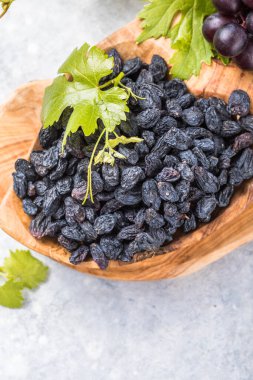 Arka planda siyah kuru üzümler, masa üstü manzaralı. Kurutulmuş meyve, sağlıklı atıştırmalık