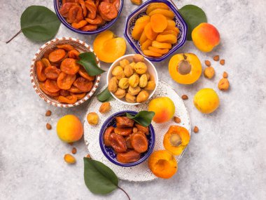 Seramik kaselerde arka planda bulunan lezzetli ve sağlıklı kayısıların farklı çeşitleri. Taze kurumuş. Sağlıklı yemek..