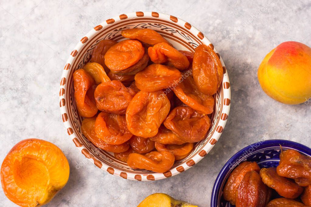 Composition from different varieties of delicious and healthy dried apricots  on a light background in ceramic bowls. Freshly dried. Healthy food.