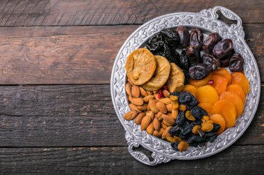 Kurutulmuş meyve ve fındık, ahşap bir kasede karıştırılır. Şekerli meyve çeşitleri. Yahudi bayramı Tu Bishvat. Boşluğu kopyala