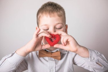 Küçük kırmızı bir kalp taşıyan çocuk, sevginin, ailenin ve umudun sembolü. Sevgililer Günü 'nde kart geçmişi. Aile ve çocukların korunmasıyla ilgili posterler..