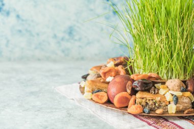 Novruz geleneksel tepsisi yeşil buğday çimi semeni veya sabzi, tatlı ve kuru meyveli pakhlava beyaz arka planda. Bahar ekinoksu, Azerbaycan kopyalama alanı