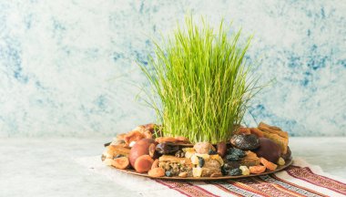 Novruz geleneksel tepsisi yeşil buğday çimi semeni veya sabzi, tatlı ve kuru meyveli pakhlava beyaz arka planda. Bahar ekinoksu, Azerbaycan kopyalama alanı