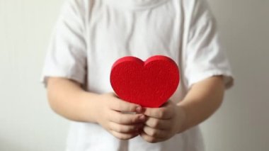 Kırmızı kalp, Sevgililer Günü 'nde küçük çocuğun ellerinde..