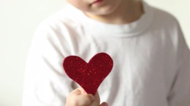 Kırmızı kalp, Sevgililer Günü 'nde küçük çocuğun ellerinde..