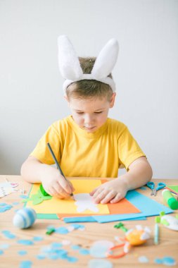 Çok renkli kağıtlardan çıkan yuvarlak tavşancıklar. Çocuk el yapımı Paskalya gemisi, DIY