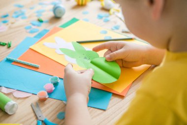 Paskalya tebrik kartı için küçük çocuk Bunny 'i tutuyor. Çocuk sanat projesi. DIY kavramı