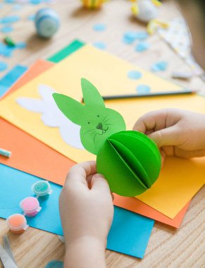 Paskalya tebrik kartı için küçük çocuk Bunny 'i tutuyor. Çocuk sanat projesi. DIY kavramı