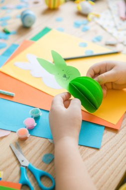 Paskalya tebrik kartı için küçük çocuk Bunny 'i tutuyor. Çocuk sanat projesi. DIY kavramı