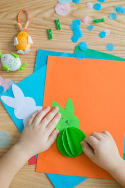 Paskalya tebrik kartı için küçük çocuk Bunny 'i tutuyor. Çocuk sanat projesi. DIY kavramı