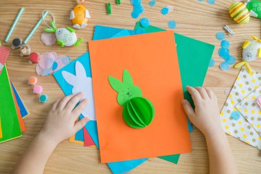 Paskalya tebrik kartı için küçük çocuk Bunny 'i tutuyor. Çocuk sanat projesi. DIY kavramı