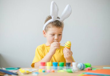 Küçük çocuk paskalya yumurtası boyadı. Çocuklarla Paskalya tatili için. Bahar için zanaat