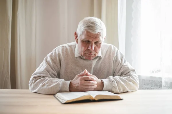 Starší Muž Modlí Čte Starou Bibli Svých Rukou — Stock fotografie