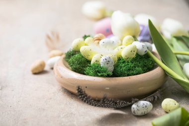 Paskalya kompozisyonu, renkli Paskalya yumurtaları ve çimento arka planda bahar çiçekleri laleleri. Paskalya kartı kopyalama alanı