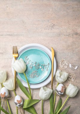 Gri masa üzerinde çiçek dekoru olan Paskalya sofrası. Zarif bir akşam yemeği. Üst Manzara. Mutlu Paskalyalar