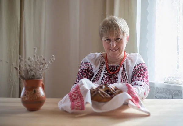 Retired woman in Ukrainian shirt baked pies for Easter