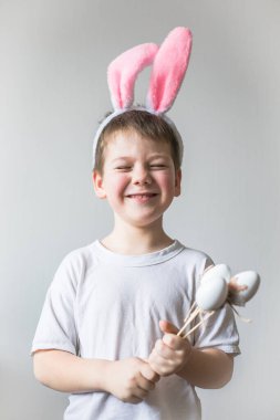 Paskalya tavşanı kulakları takan sevimli çocuk, gülümsüyor..