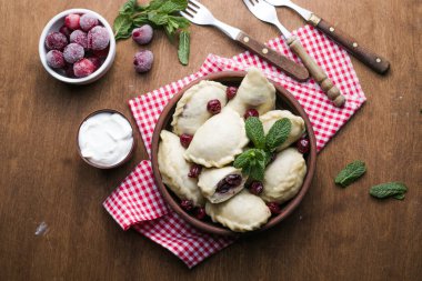 Kirazlı Pierogi. Vareniki böreği. Geleneksel Ukrayna yemekleri. Ekşi krema ve böğürtlenle pişirilip servis ediliyor.