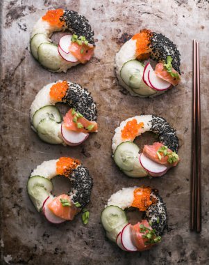 Somon, salatalık ve turplu suşi çörekleri. Melez Yiyecekler.