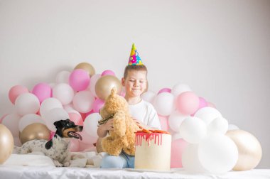 Köpeğiyle birlikte beyaz balonlu küçük bir çocuk. Parti balonlu küçük bir çocuk, kutlama. Doğum günü, mutluluk, çocukluk, bak.