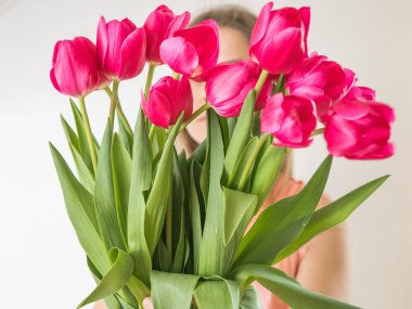 Meçhul kavram. Lale desenli güzel bir kadın. Bahar portresi. Parlak pembe çiçekler kızın ellerinde.